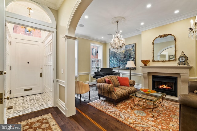 foyer featuring arched walkways, crown molding, decorative columns, recessed lighting, and dark wood-type flooring