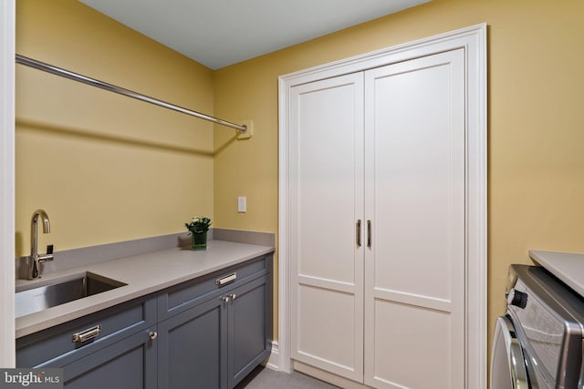 laundry room featuring cabinet space, separate washer and dryer, and a sink