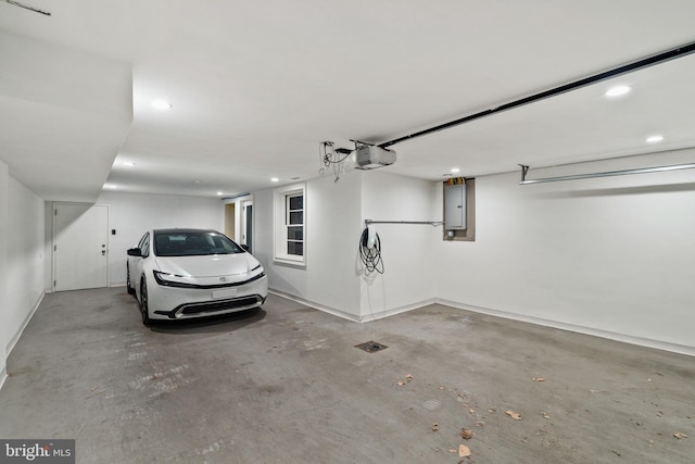 garage featuring recessed lighting, electric panel, and a garage door opener