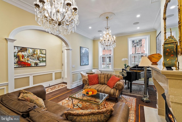 sitting room featuring arched walkways, a wainscoted wall, wood finished floors, and crown molding