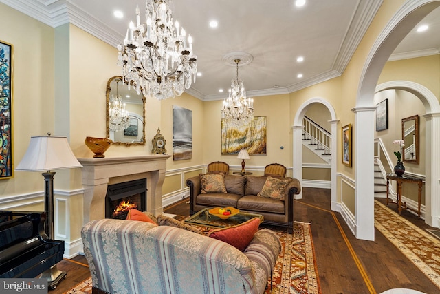 living area featuring a warm lit fireplace, stairs, arched walkways, and wood finished floors