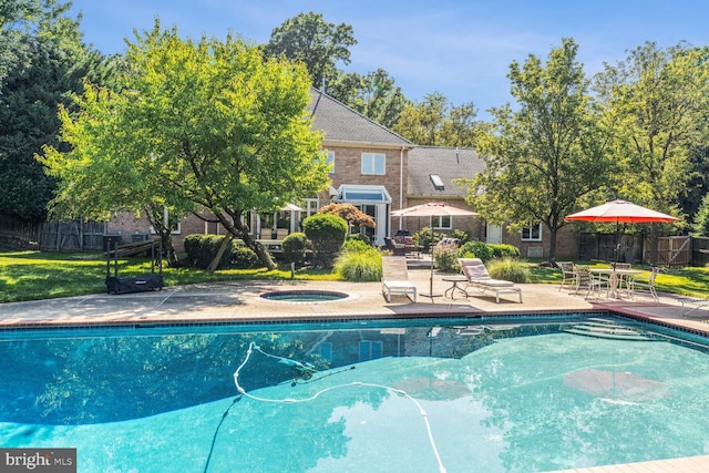 outdoor pool with a patio area, a jacuzzi, and fence