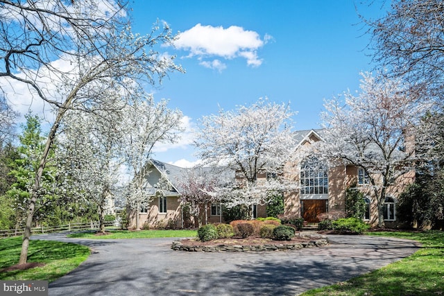 view of front of house with a front lawn, fence, and driveway