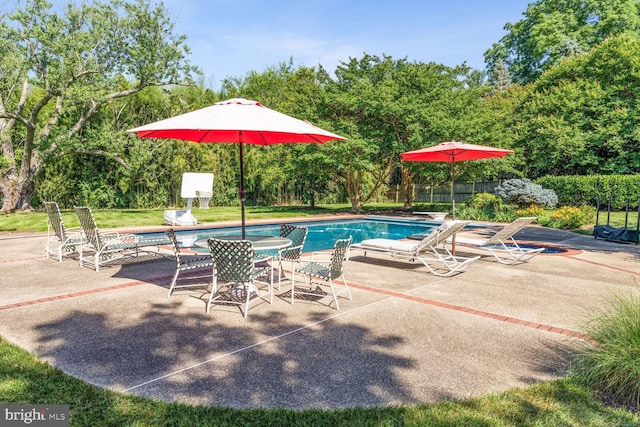 pool with a patio area and a yard