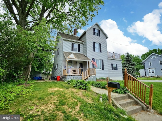 view of front facade with covered porch and a front yard