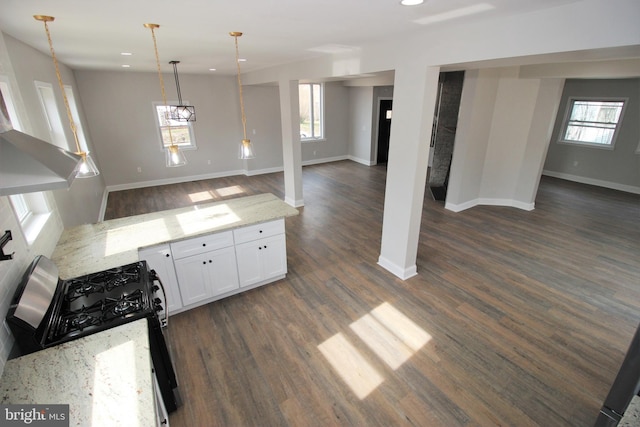 kitchen featuring white cabinetry, light stone counters, plenty of natural light, and pendant lighting