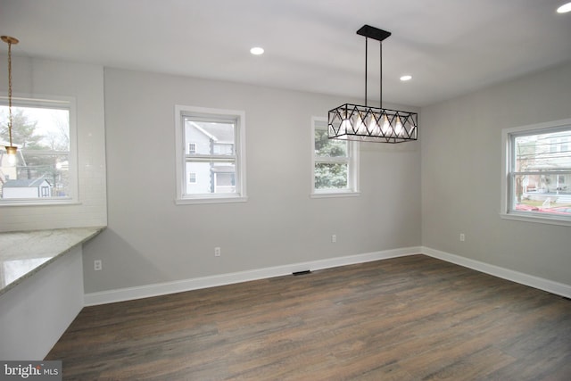 unfurnished dining area featuring dark hardwood / wood-style floors and a healthy amount of sunlight