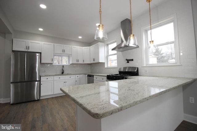 kitchen featuring wall chimney exhaust hood, white cabinetry, kitchen peninsula, and appliances with stainless steel finishes