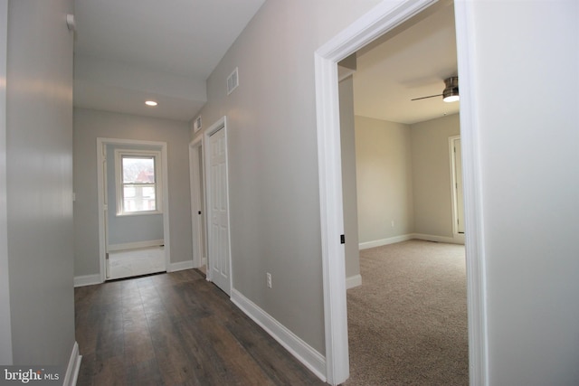 corridor featuring dark colored carpet