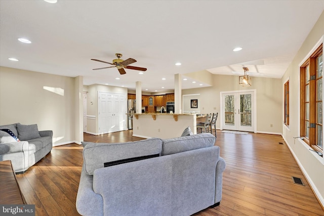 living room featuring french doors, dark hardwood / wood-style flooring, and ceiling fan