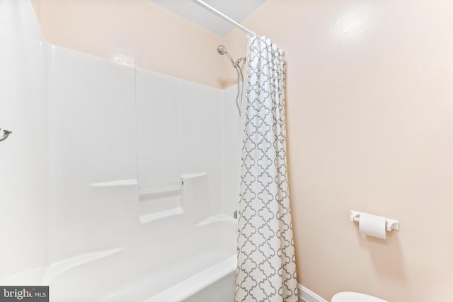 bathroom featuring shower / bath combination with curtain and toilet