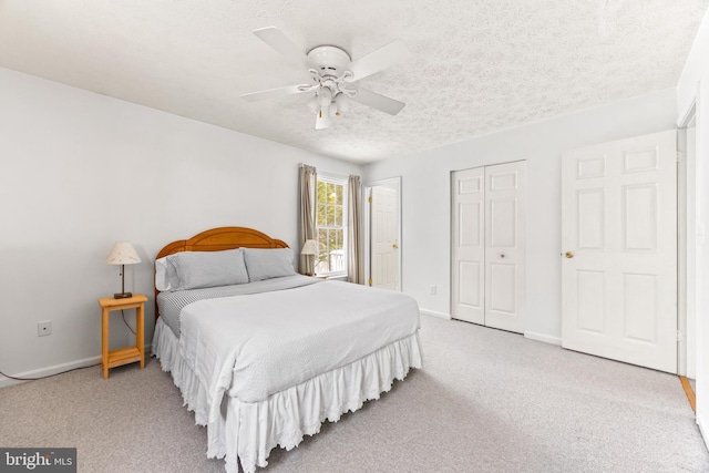 carpeted bedroom featuring ceiling fan and a textured ceiling