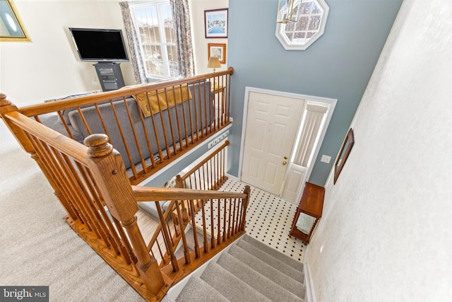 stairway featuring carpet floors and a towering ceiling