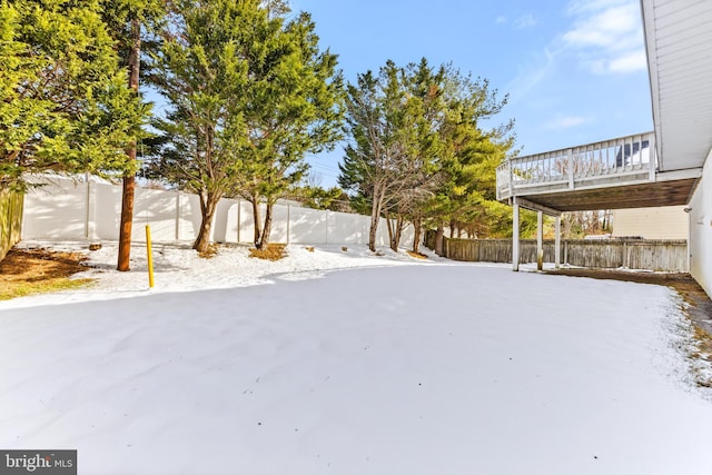 yard covered in snow with a deck