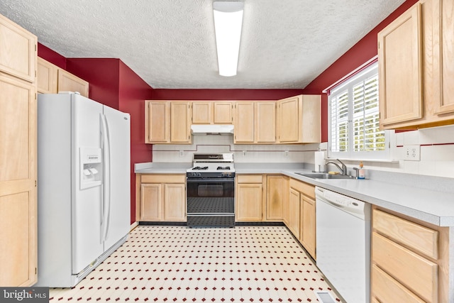 kitchen with a textured ceiling, sink, white appliances, and light brown cabinets