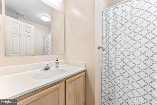 bathroom featuring vanity and curtained shower