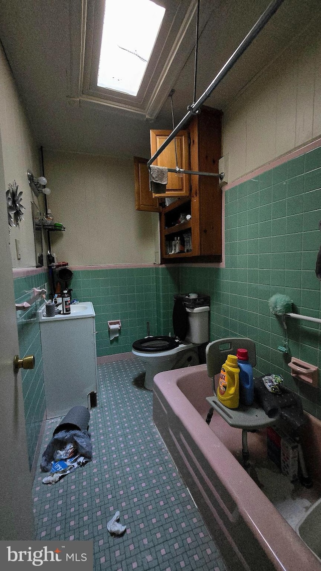 bathroom with toilet, tile walls, and a tub