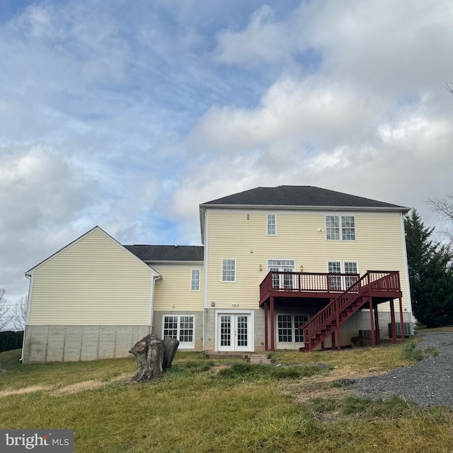 rear view of property with a yard and a wooden deck