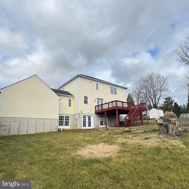 back of house with an outbuilding, a deck, and a lawn