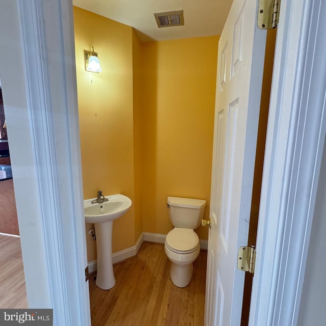 bathroom featuring hardwood / wood-style floors, toilet, and sink