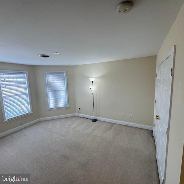 unfurnished room with light colored carpet