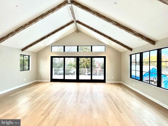 unfurnished living room with lofted ceiling with beams and light wood-type flooring