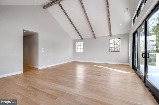 spare room featuring high vaulted ceiling, light hardwood / wood-style floors, and beamed ceiling