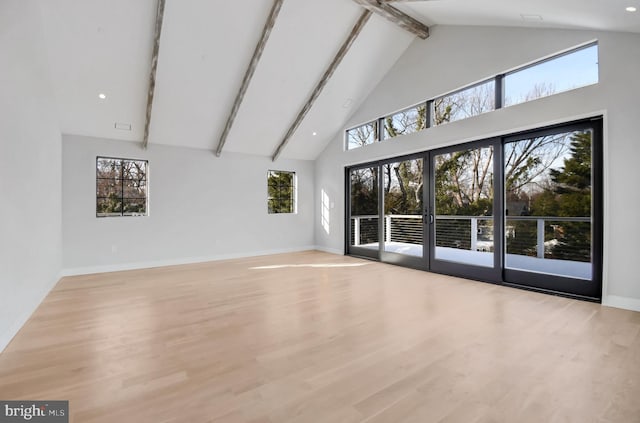 unfurnished living room with high vaulted ceiling, french doors, beamed ceiling, and light wood-type flooring