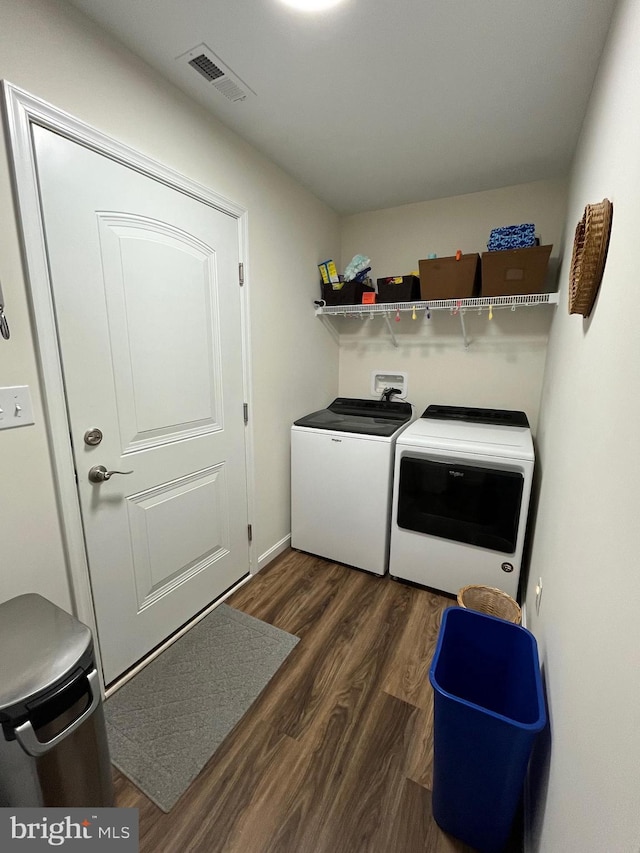 washroom with dark hardwood / wood-style floors and washing machine and dryer