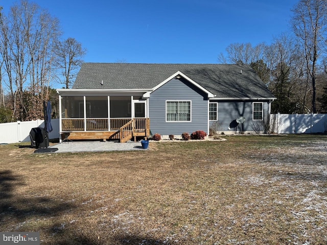 back of property with a yard, a patio, and a sunroom