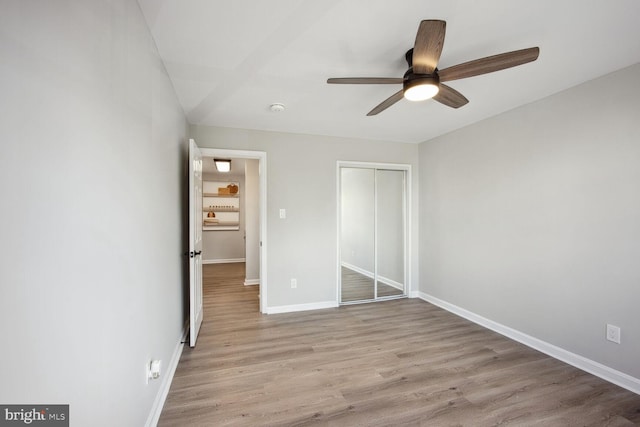 unfurnished bedroom with ceiling fan, a closet, and light hardwood / wood-style flooring