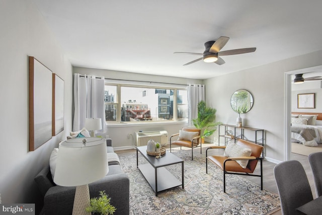 living room featuring ceiling fan, wood-type flooring, and a wall mounted AC