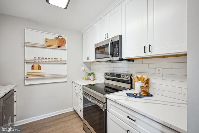 kitchen featuring backsplash, white cabinetry, stainless steel appliances, and light hardwood / wood-style flooring