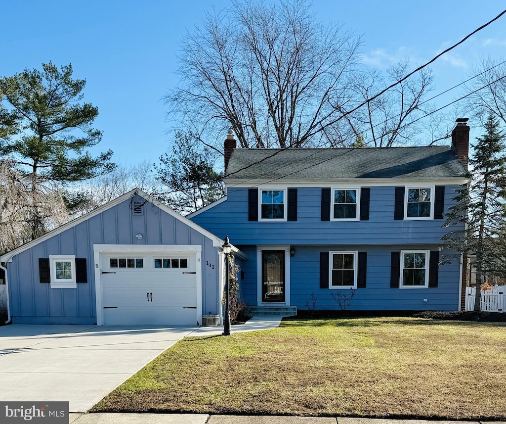 view of front of property featuring a front yard and a garage