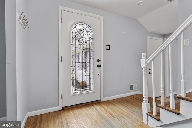 foyer entrance with light hardwood / wood-style floors and lofted ceiling