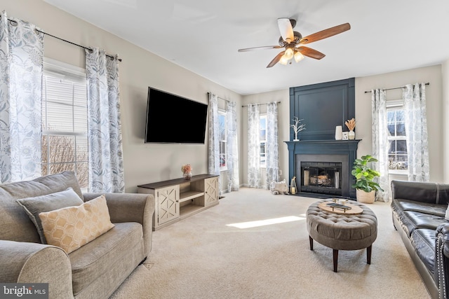 carpeted living room with a fireplace, a wealth of natural light, and ceiling fan