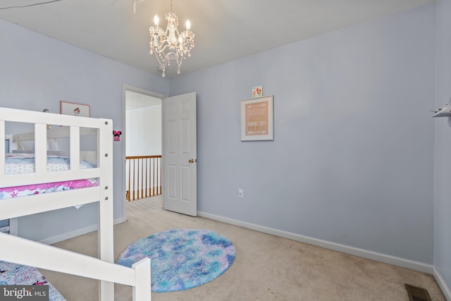 carpeted bedroom featuring an inviting chandelier