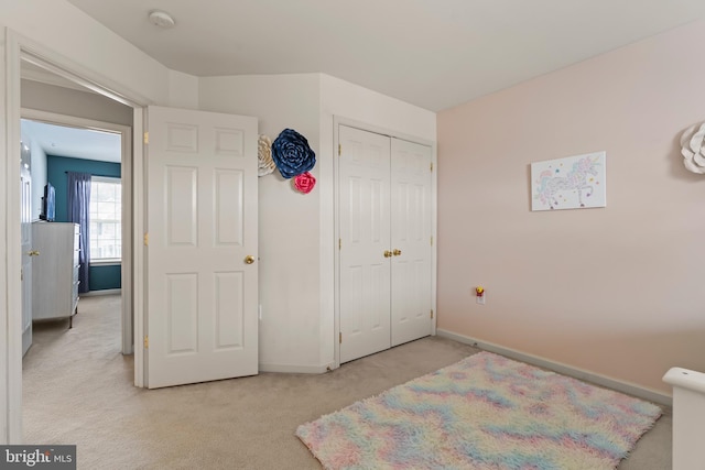 bedroom with light colored carpet and a closet