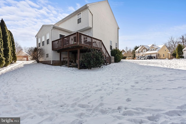 snow covered house featuring a deck