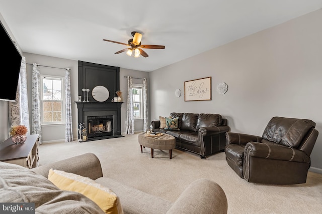 carpeted living room with ceiling fan and a fireplace