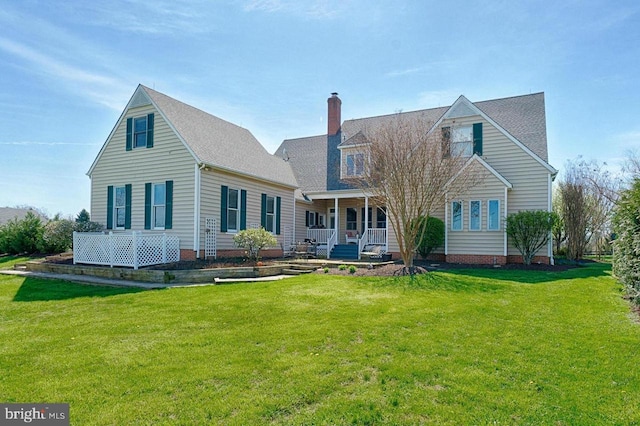 rear view of house with a lawn and a porch