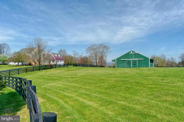 view of yard featuring a rural view and an outbuilding