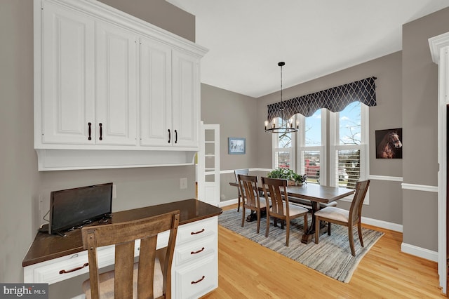 dining area featuring a notable chandelier and light wood-type flooring