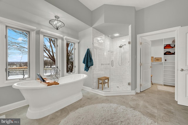 bathroom with independent shower and bath, a wealth of natural light, and a notable chandelier