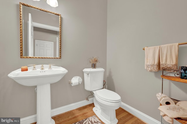 bathroom featuring toilet, wood-type flooring, and sink