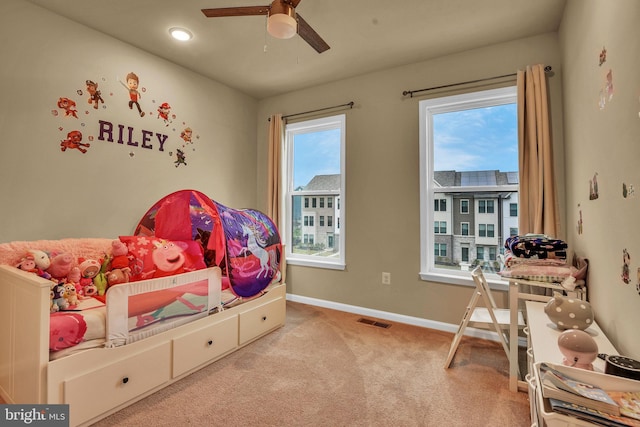 carpeted bedroom with ceiling fan and multiple windows