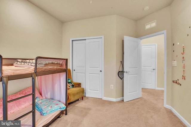 bedroom featuring light carpet and a closet