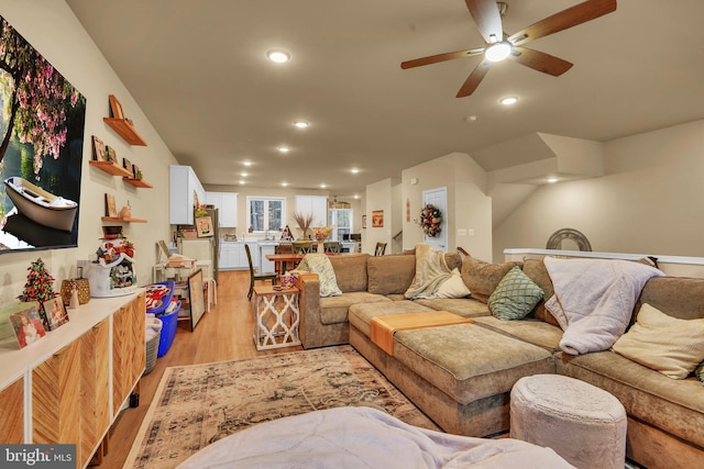 living room with light hardwood / wood-style flooring and ceiling fan