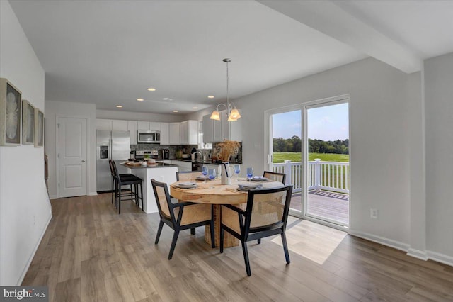 dining room with a notable chandelier, light hardwood / wood-style floors, and sink