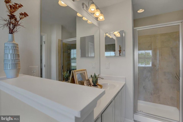 bathroom with a shower with door and vanity